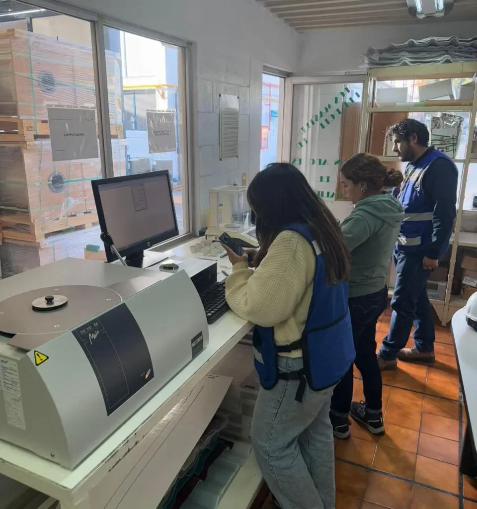 Equipo de trabajadores ejecutando un mantenimiento de equipos de laboratorio, revisando sistemas técnicos con herramientas profesionales.
